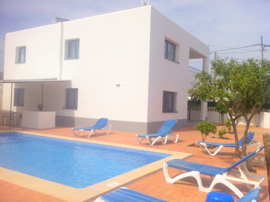 Pool area with sunloungers at Villa Torres